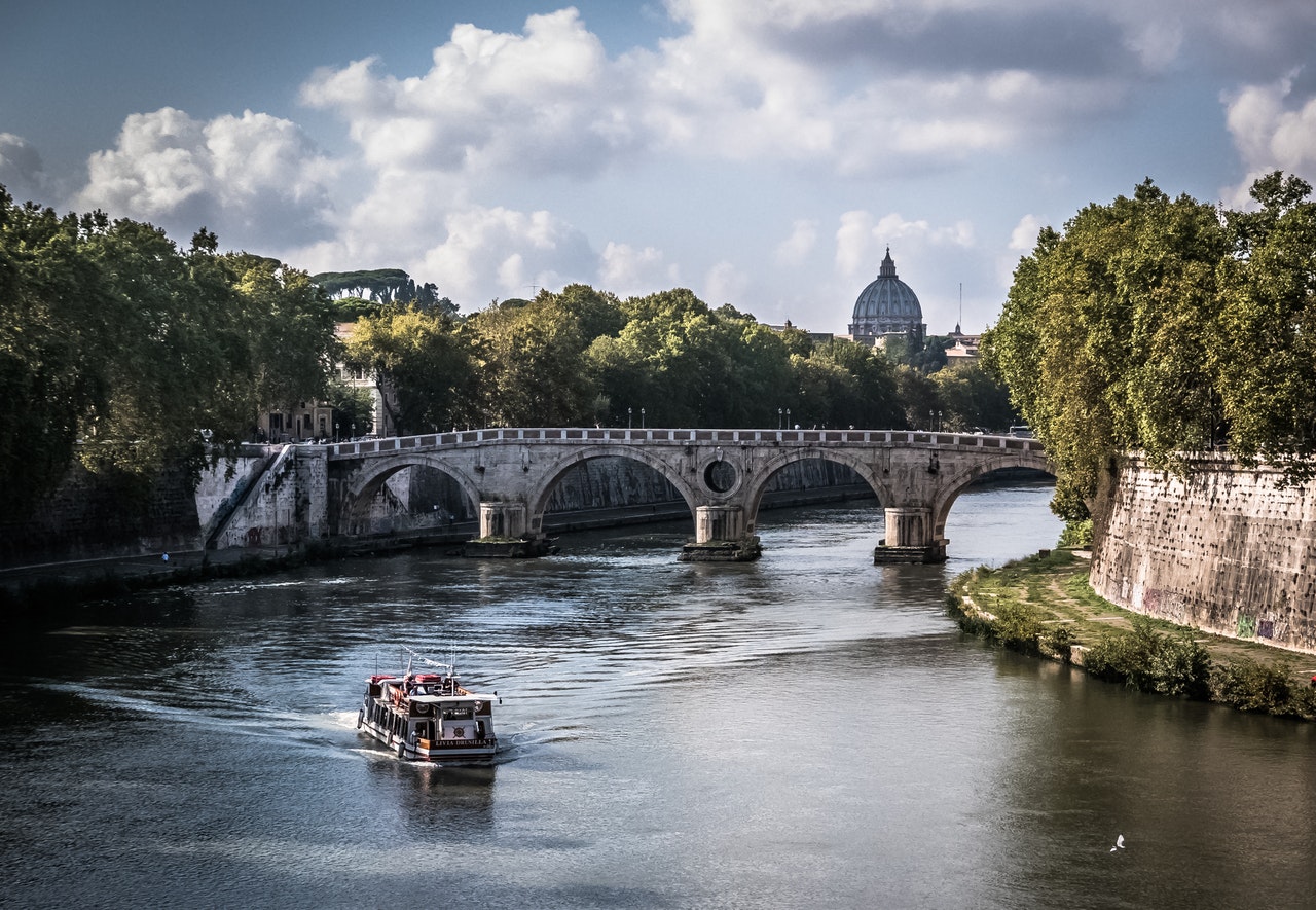 Utsikt över floden i Rom med en båt på vattnet.
